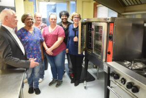 County Commission President Ed Hawkins talks with cooks and manager about the new equipment they got form funding form commission in photo left to right is Hawkins, Mary K. Layman, Kitchen food, Megan McDonald, Assistand Cook, Patricia Costello, Head Cook, Joy Thomas , Special Meals and Sara Bishop, manager Meals on Wheels.